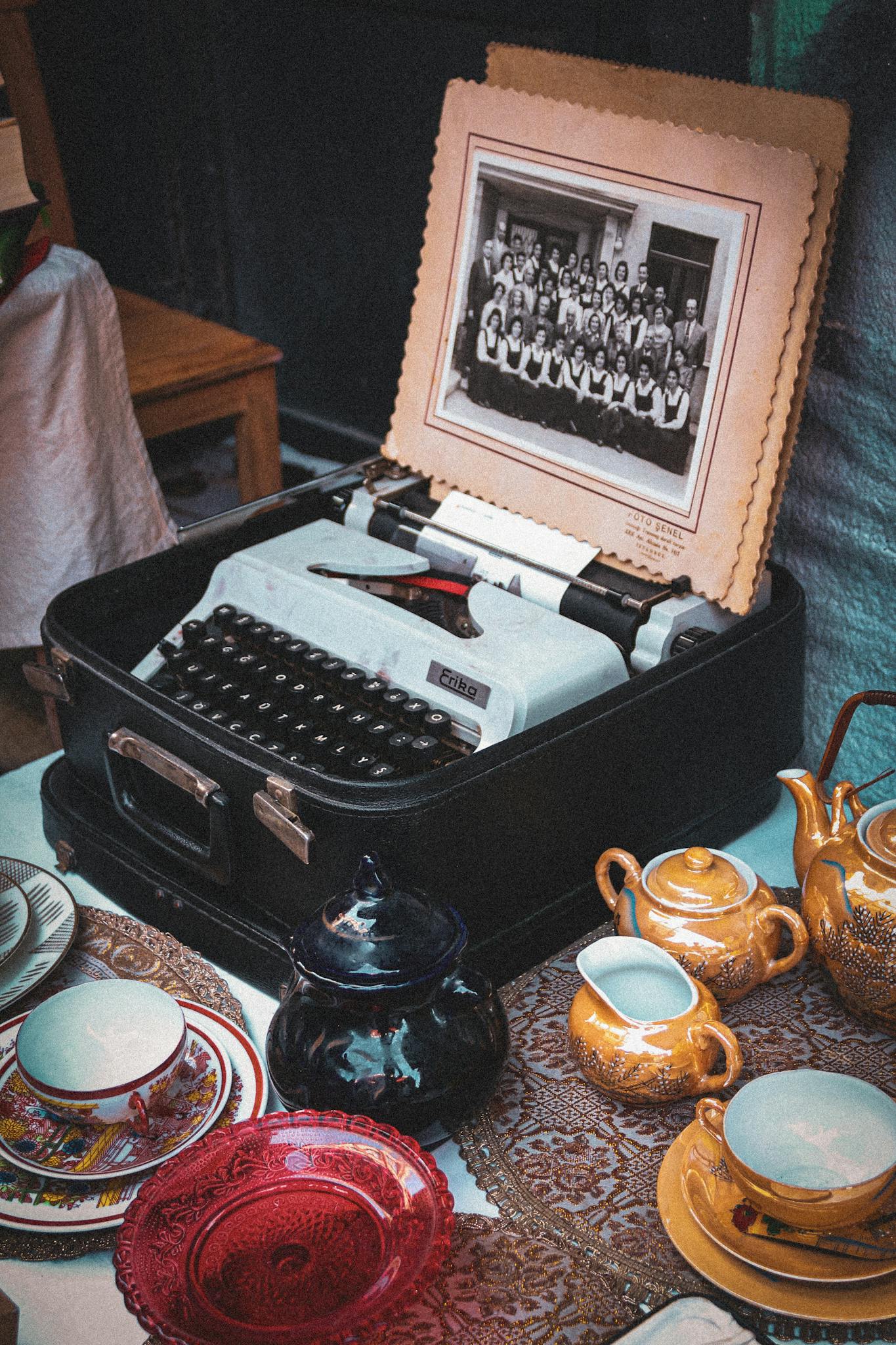 Charming display of a vintage typewriter and porcelain tea set with antique decor.