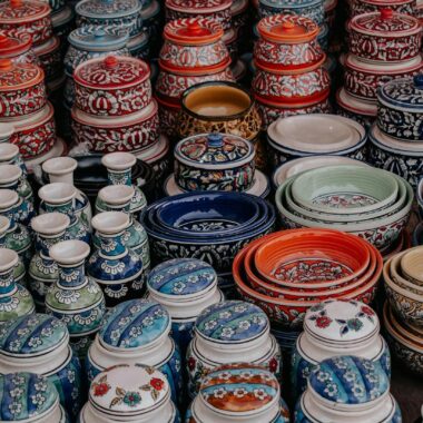 Vibrant handmade pottery displayed in a market setting, showcasing intricate patterns and rich colors.
