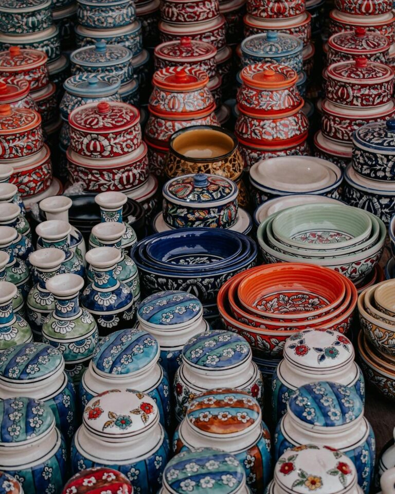 Vibrant handmade pottery displayed in a market setting, showcasing intricate patterns and rich colors.