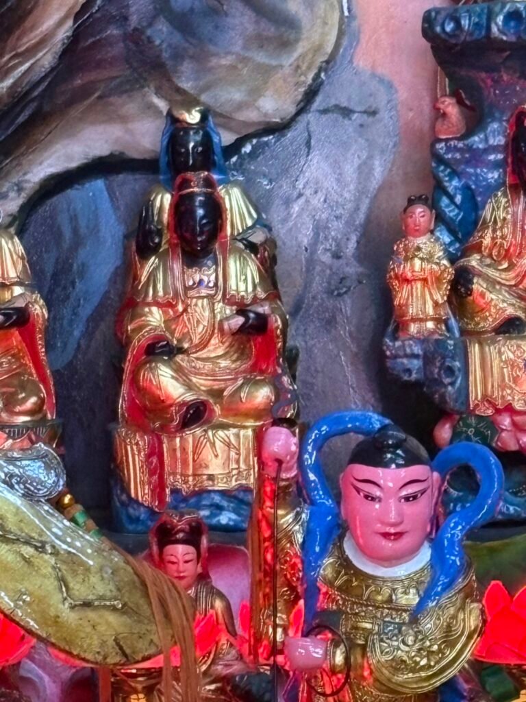 Black-faced Guanyin figures and attendants within the temple shrine