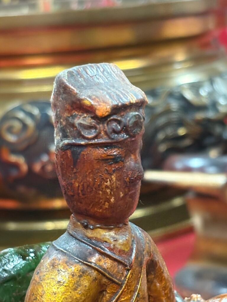 Close frontal detail of the wooden scholar figure